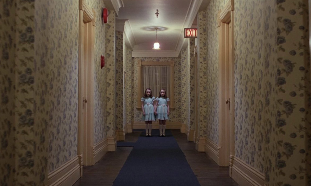 The Grady twins stand at the end of an Overlook corridor - The Shining trivia