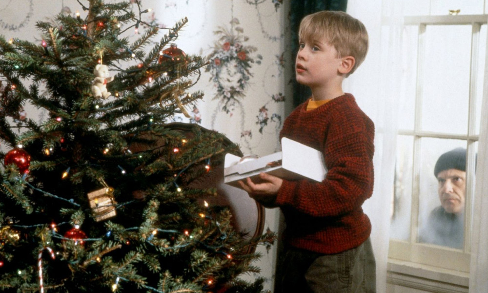 Kevin (Macaulay Culkin) decorates the tree whilst Harry (Joe Pesci) watches in Home Alone
