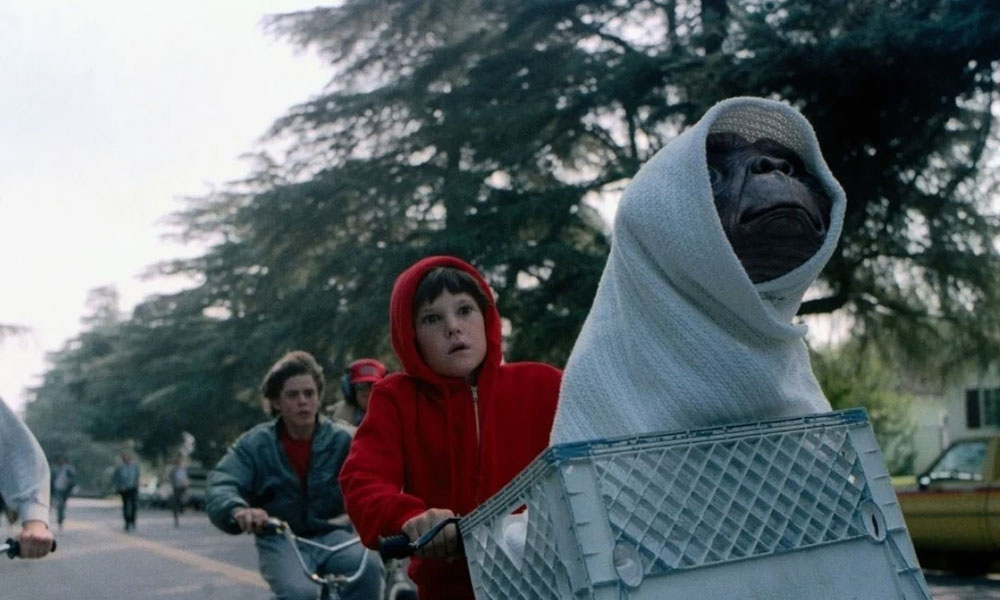 Elliot rides his bike with E.T in the basket